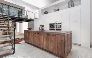 Esprit loft contemporain pour cette cuisine METROPOLE EVOLUTION de La Cuisine Française qui associe métal et bois ; la cuisine est réalisée en lames de chêne massif à nœuds, défibré et traité dans un esprit « vieux bois »