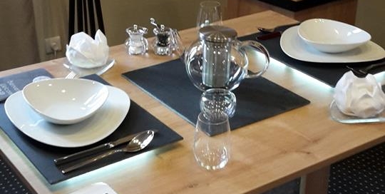 Table en placage chêne avec verre décoratif au niveau du piètement sur lequel repose un bambou