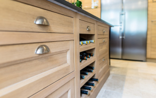 crémaillère bois dans niche ouverte plaquée de chêne pour recevoir les bouteilles de vin