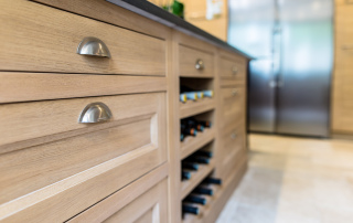 crémaillère bois dans niche ouverte plaquée de chêne pour recevoir les bouteilles de vin