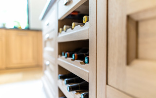 crémaillère bois dans niche ouverte plaquée de chêne pour recevoir les bouteilles de vin